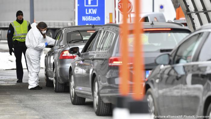 A medical worker on the border of Austria with Italy measures the temperature to the driver of a car from Italy.